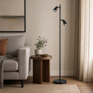 FL2H black dual-head integrated LED floor spotlight standing beside residential seating with both heads switched off