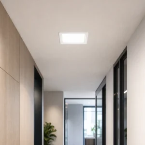 Square recessed backlit LED small panel installed flush in a dry office corridor ceiling