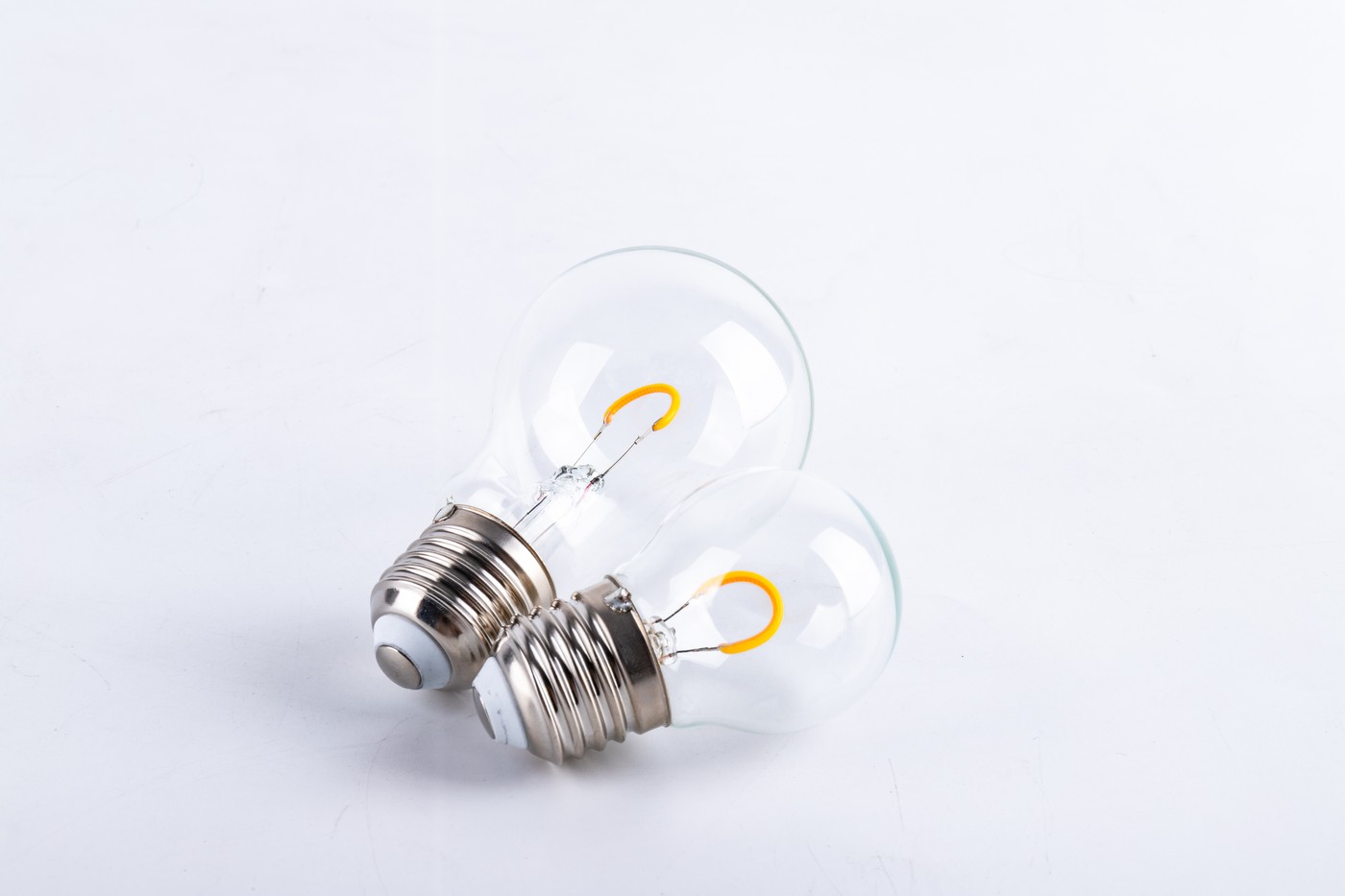 Close view of curved flexible LED filaments inside clear glass bulbs