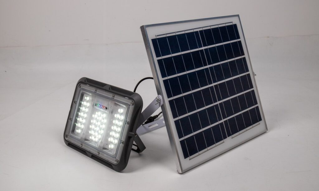 New Lights solar flood light illuminated beside its photovoltaic panel