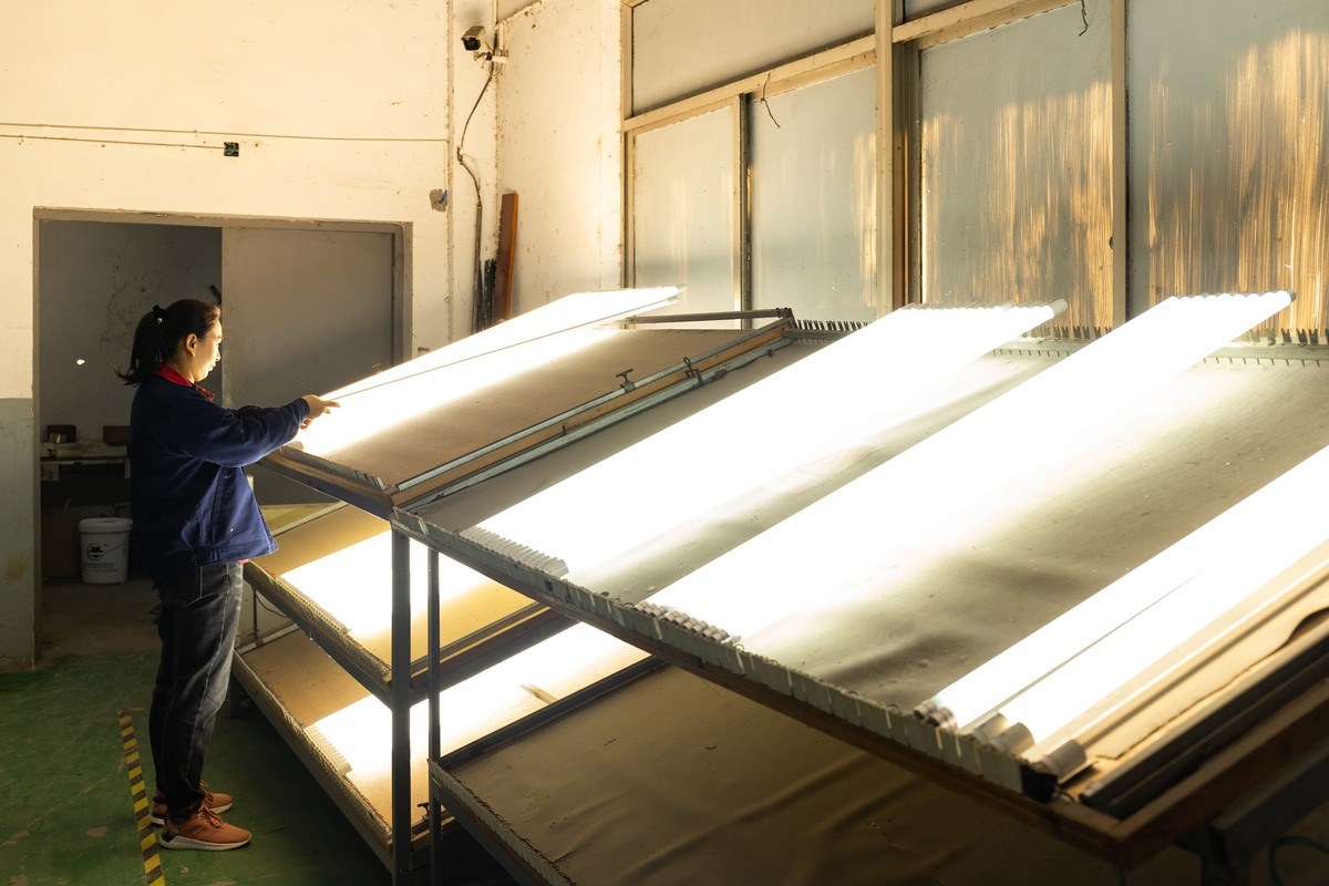 New Lights worker performing in-process inspection of illuminated linear products