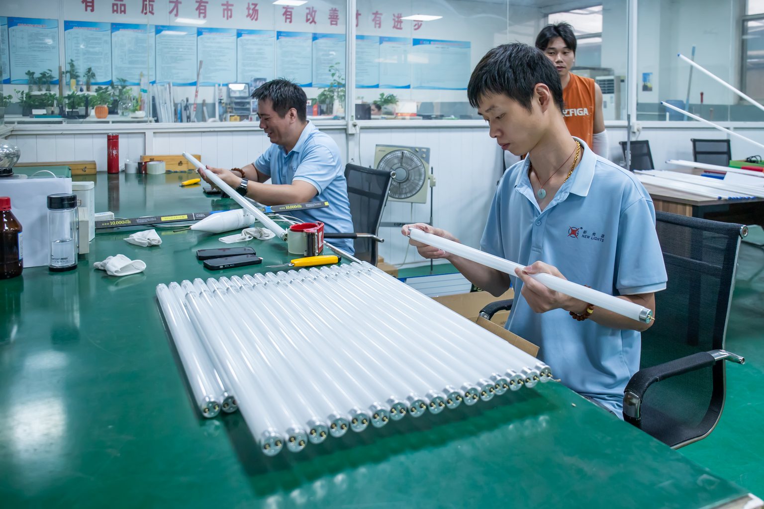 New Lights team inspecting LED tubes at a quality-control workstation