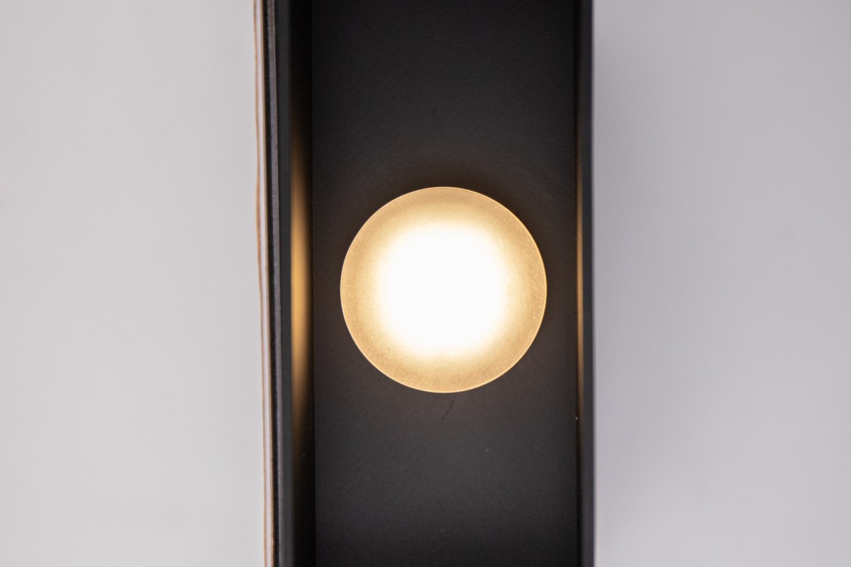 Illuminated New Lights outdoor wall light showing its up-and-down beam pattern on a wall